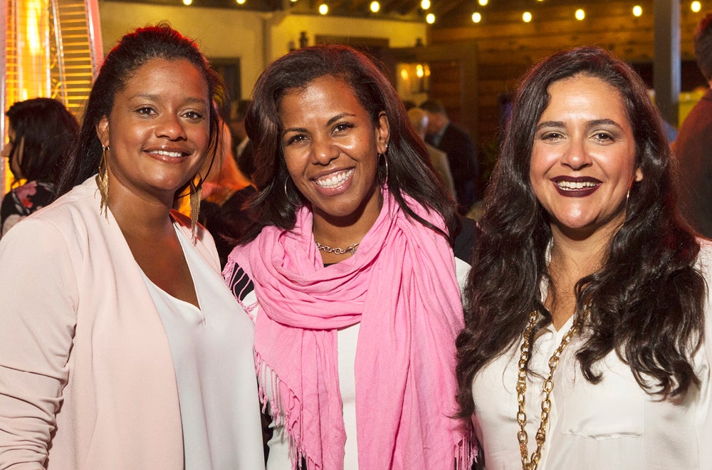 three women of color smiling at foundation event