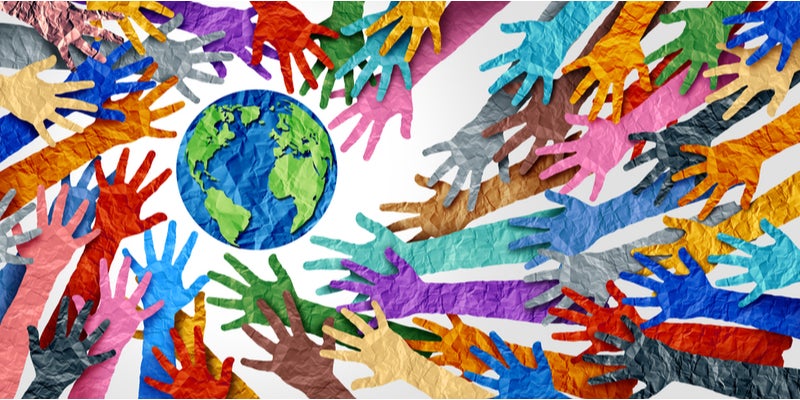 colorful paper hands reaching for a globe