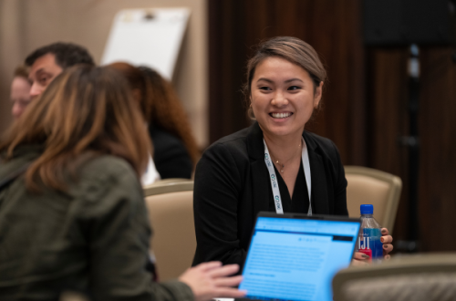 diverse woman at a conference table smiling 
